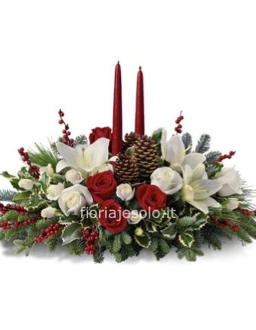 Composizione natalizia con fiori rossi e bianchi, candele, abete con altri decori.