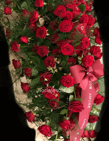 Cuscino floreale di rose rosse, verdi vari, nastro in tessuto