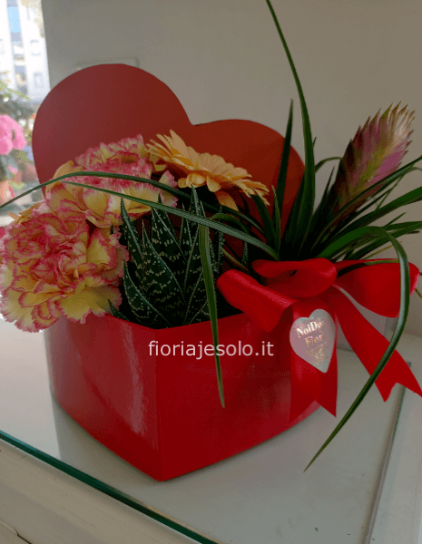 Elegante cuore rosa con piante e fiori freschi